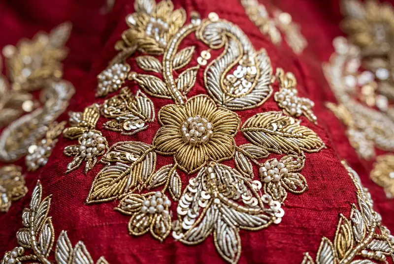 Close-up of zardozi embroidery work on red bridal fabric at Chandni Chowk