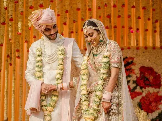 Coordinated couple wedding outfits India — pastel lehenga and sherwani styled for Hindu ceremony